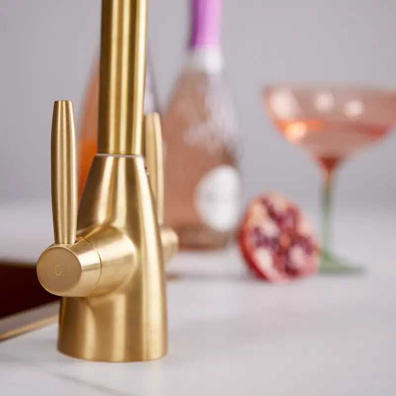 Close-up of the dual lever quarter turn handles on the Astrid brushed brass kitchen tap
