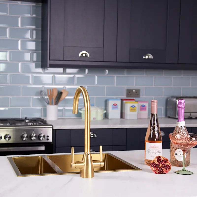 Brushed brass Astrid kitchen tap in a modern navy kitchen with white marble worktop