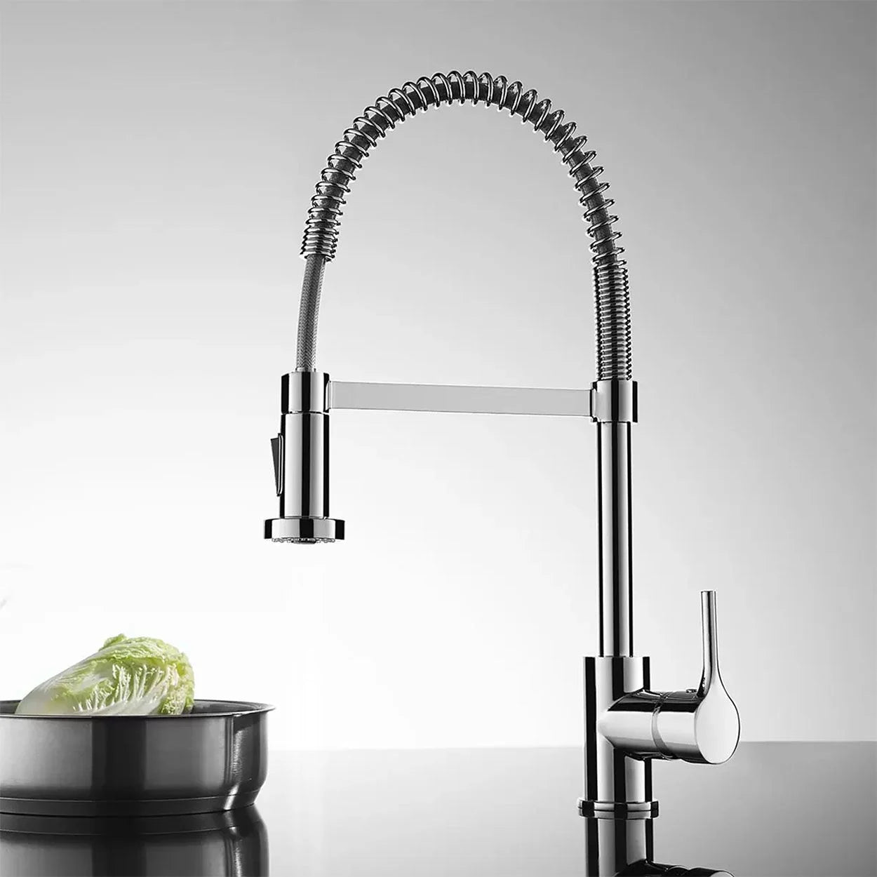 Deva Spring chrome pull-out spray kitchen tap installed on modern kitchen with a plate of lettuce at IrishBath.ie