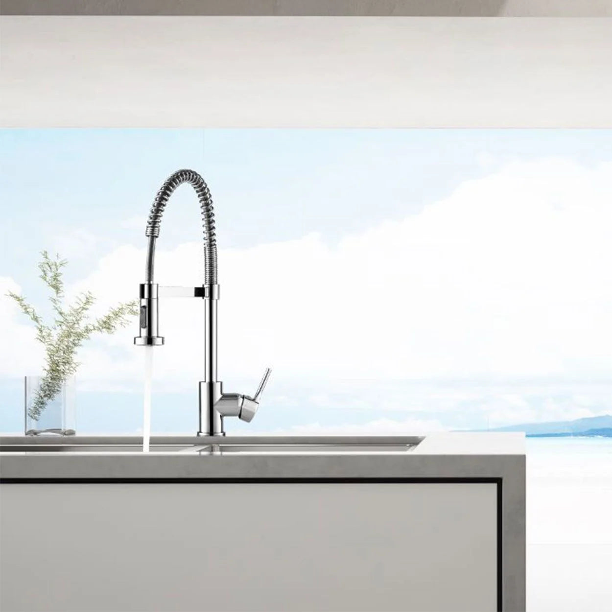 Deva Spring chrome pull-out spray kitchen tap installed on modern sink while rinsing at IrishBath.ie