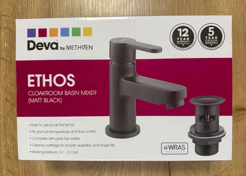 Deva Ethos matt black basin mixer tap and click-clack waste in original retail packaging on ta table