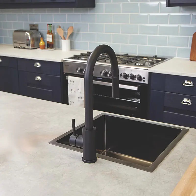 Back side view of matt black pull-out kitchen mixer tap installed on black countertop by Ellsi (Etal) at IrishBath