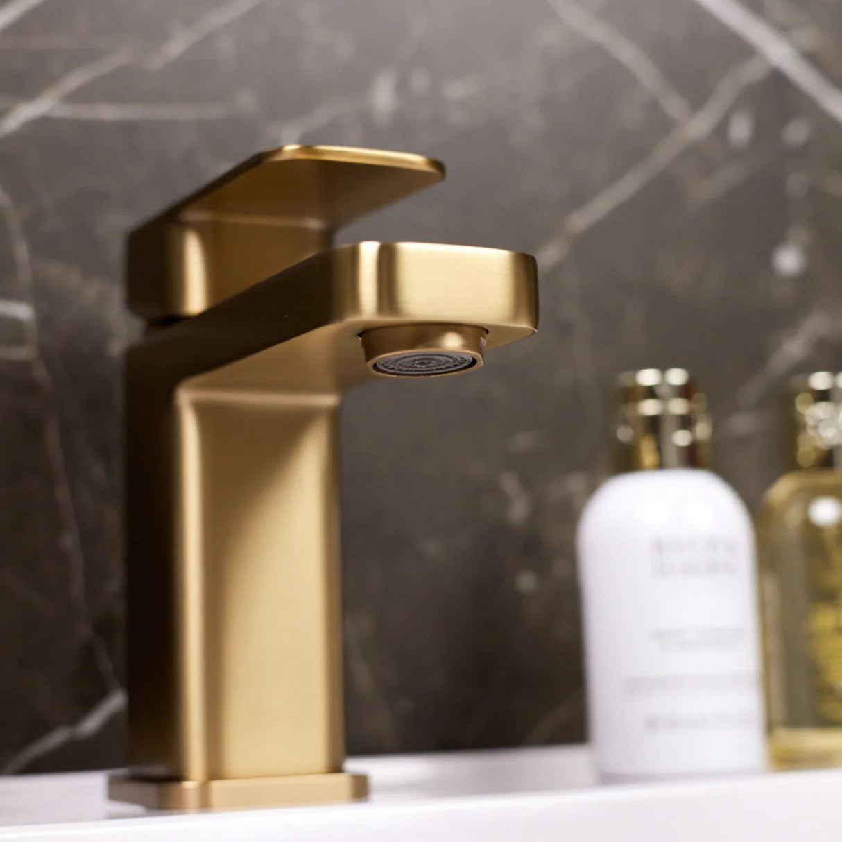 Gold ellsi etal basin faucet on a bathroom counter 