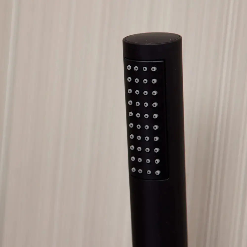 Black shower head with multiple nozzles on a beige background by Ellsi Kinlin in Ireland