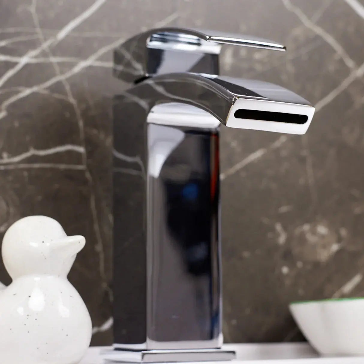 Kinlin Chrome Waterfall bathroom faucet with a marble wall background