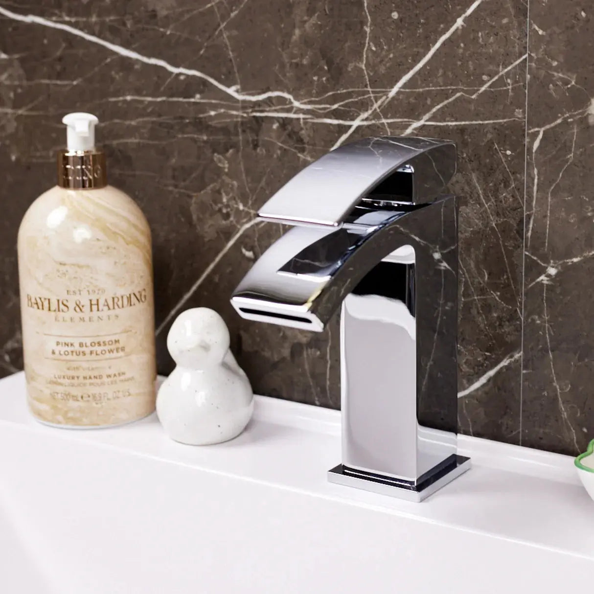 Chrome square waterfall basin sink tap Kinlin (Ellsi/Etal) in Ireland on a marble wall background