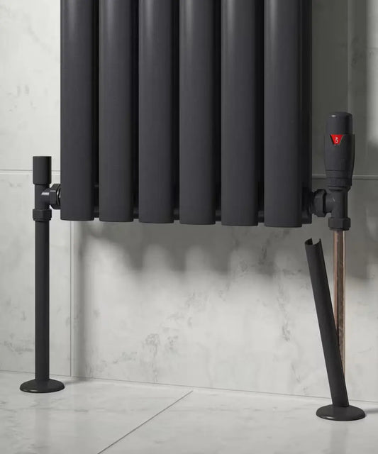Black radiator with the pipe sleeves 15mm installed on radiator pipework at IrishBath