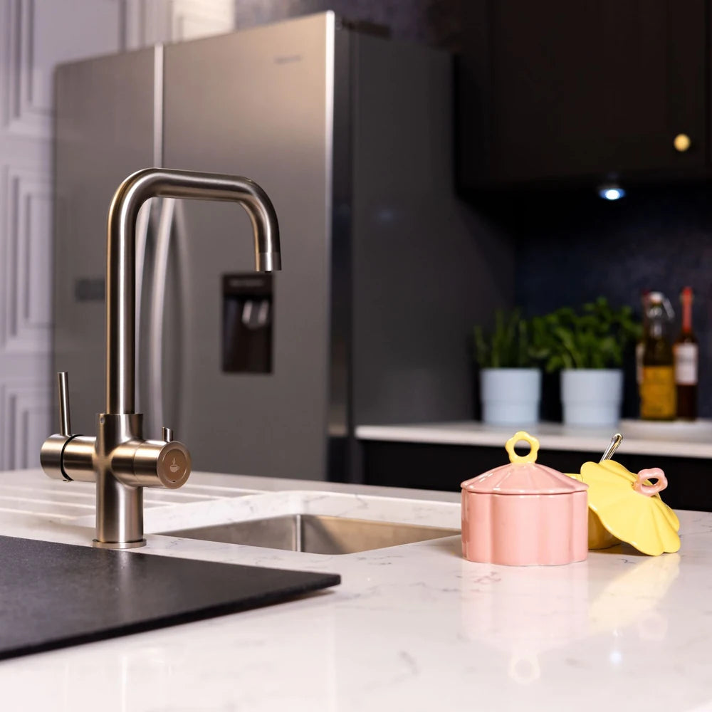 Brushed steel boiling hot water tap beside a stainless American fridge freezer in a modern kitchen