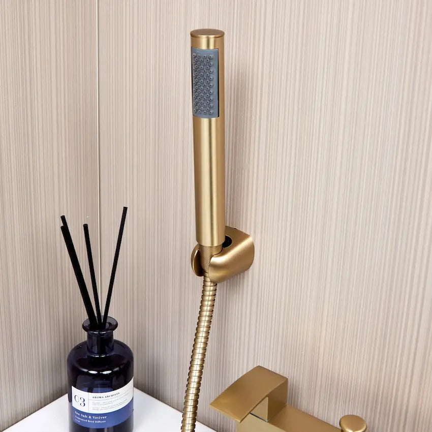 Brushed brass bath tap with hand shower close-up
