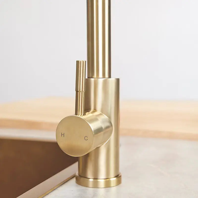 Single lever control on brushed brass pull-out kitchen tap installed on sink at IrishBath