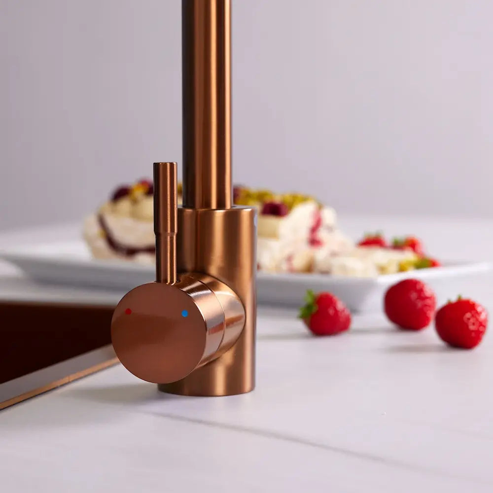 Close-up of the single lever and brushed copper body of the Tivoli kitchen tap, with hot and cold markers
