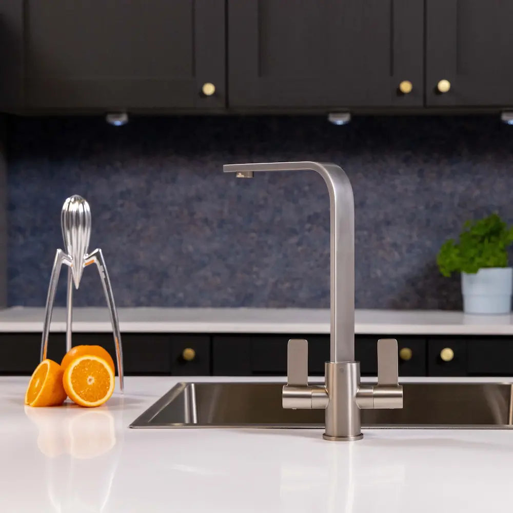 Brushed steel Stroud kitchen tap above a stainless undermount sink in a dark kitchen with a navy speckled splashback and black units