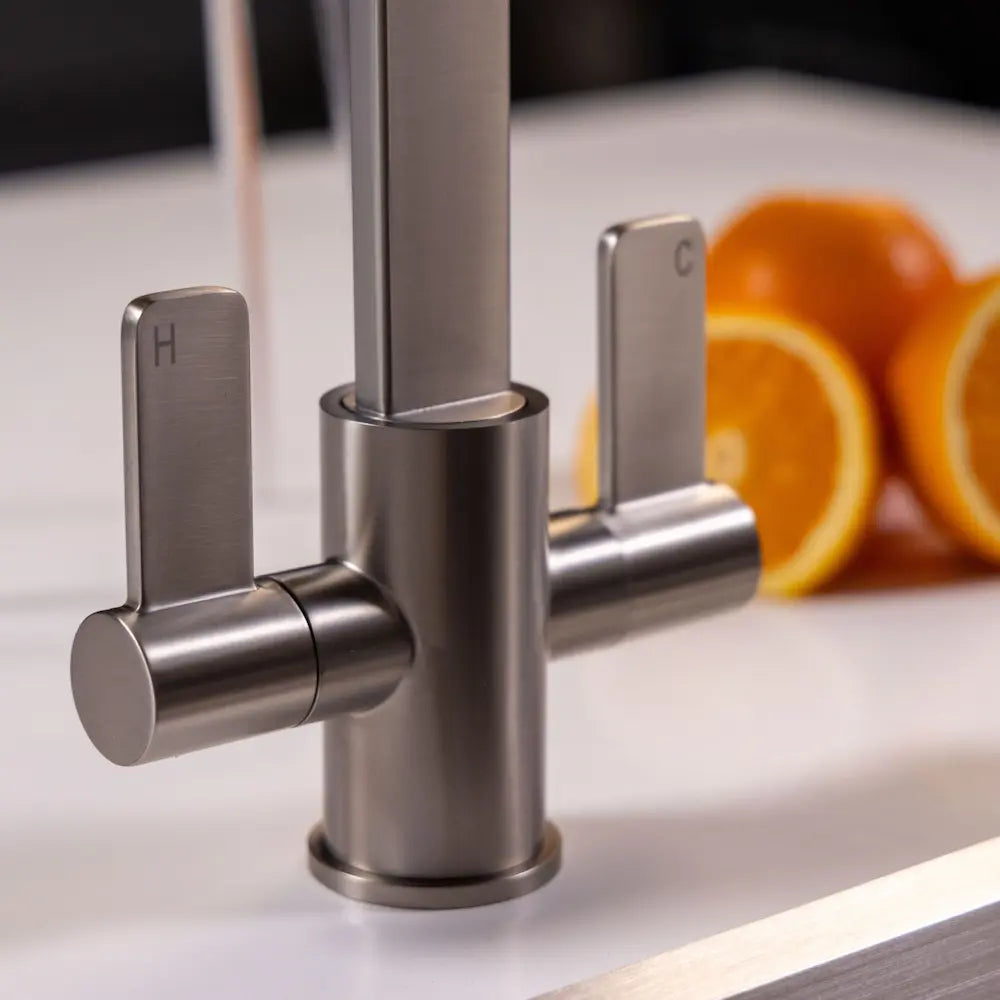 Close view of the two quarter-turn levers on the brushed steel Stroud, marked H and C, on a white worktop