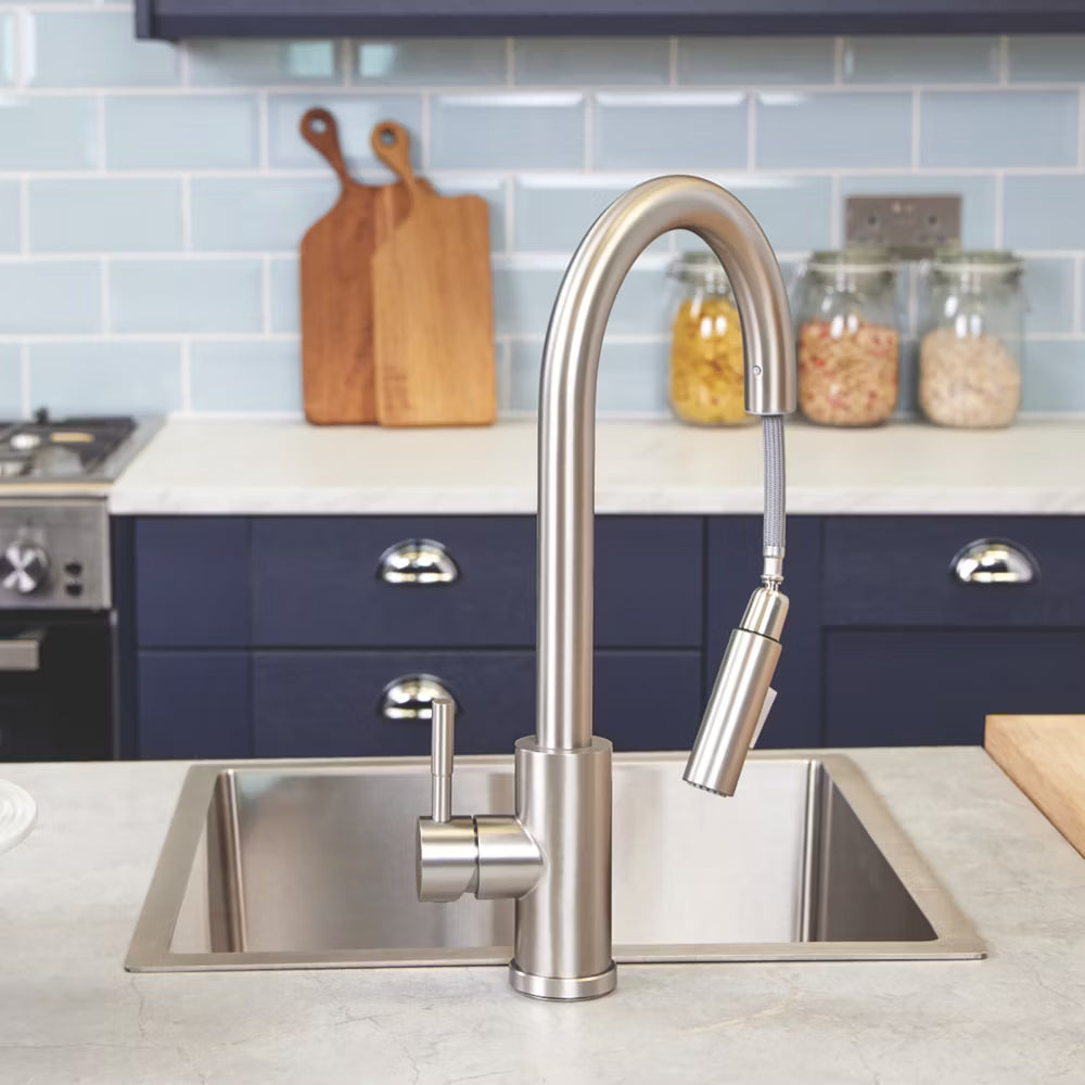 The Cato's pull-out spray head drawn out of the spout and hanging on its braided hose above a stainless steel sink.
