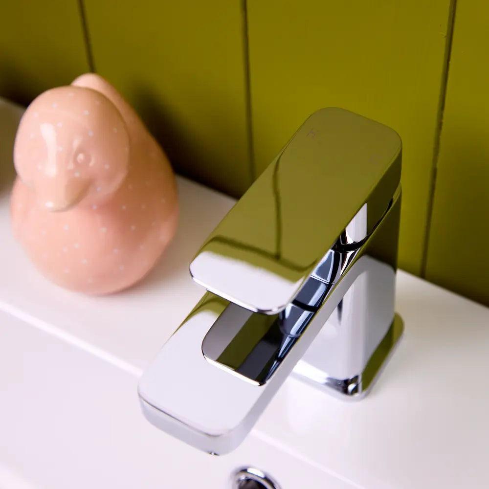 Close view of the chrome Lanza basin tap lever, with the hot and cold markings visible on its upper face.