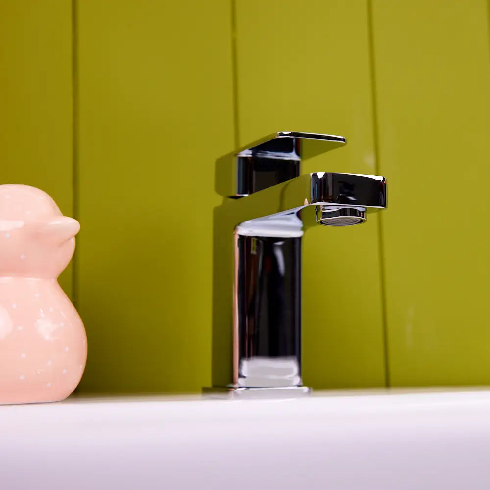 Side profile of the chrome Lanza basin tap on a white basin rim, showing the 85 mm spout outlet height and the aerator under the squared spout.
