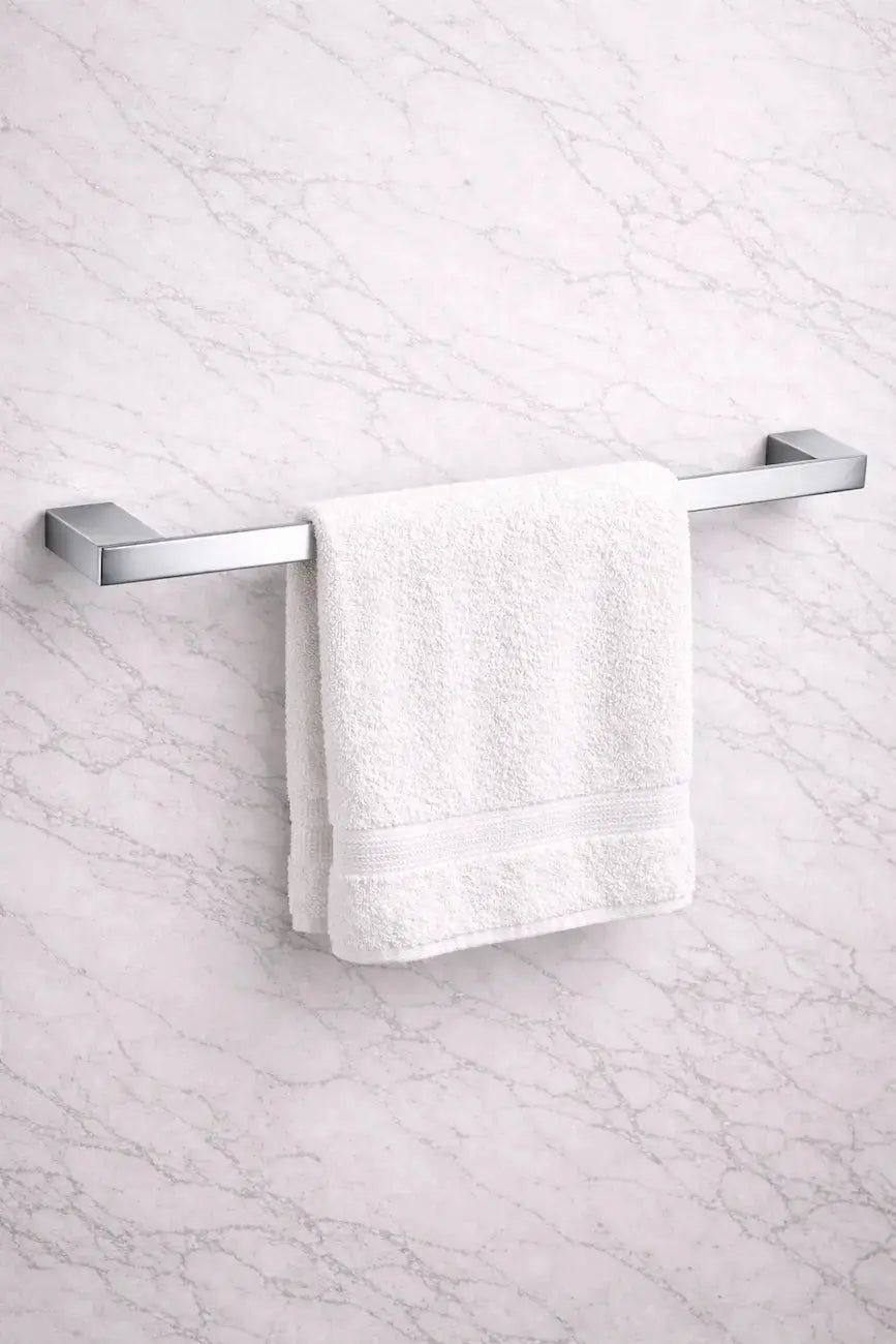 modern chrome towel bar installed on marble bathroom wall with white towel on it at Irishbath