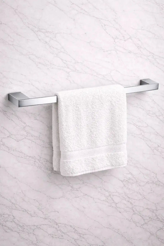 modern chrome towel bar installed on marble bathroom wall with white towel on it at Irishbath