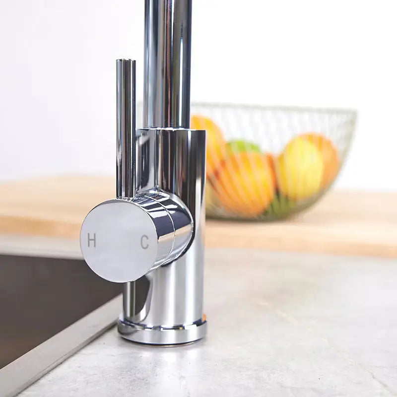 Modern chrome pull-out kitchen mixer tap CATO model with a close-up handle and fruits on backgroung