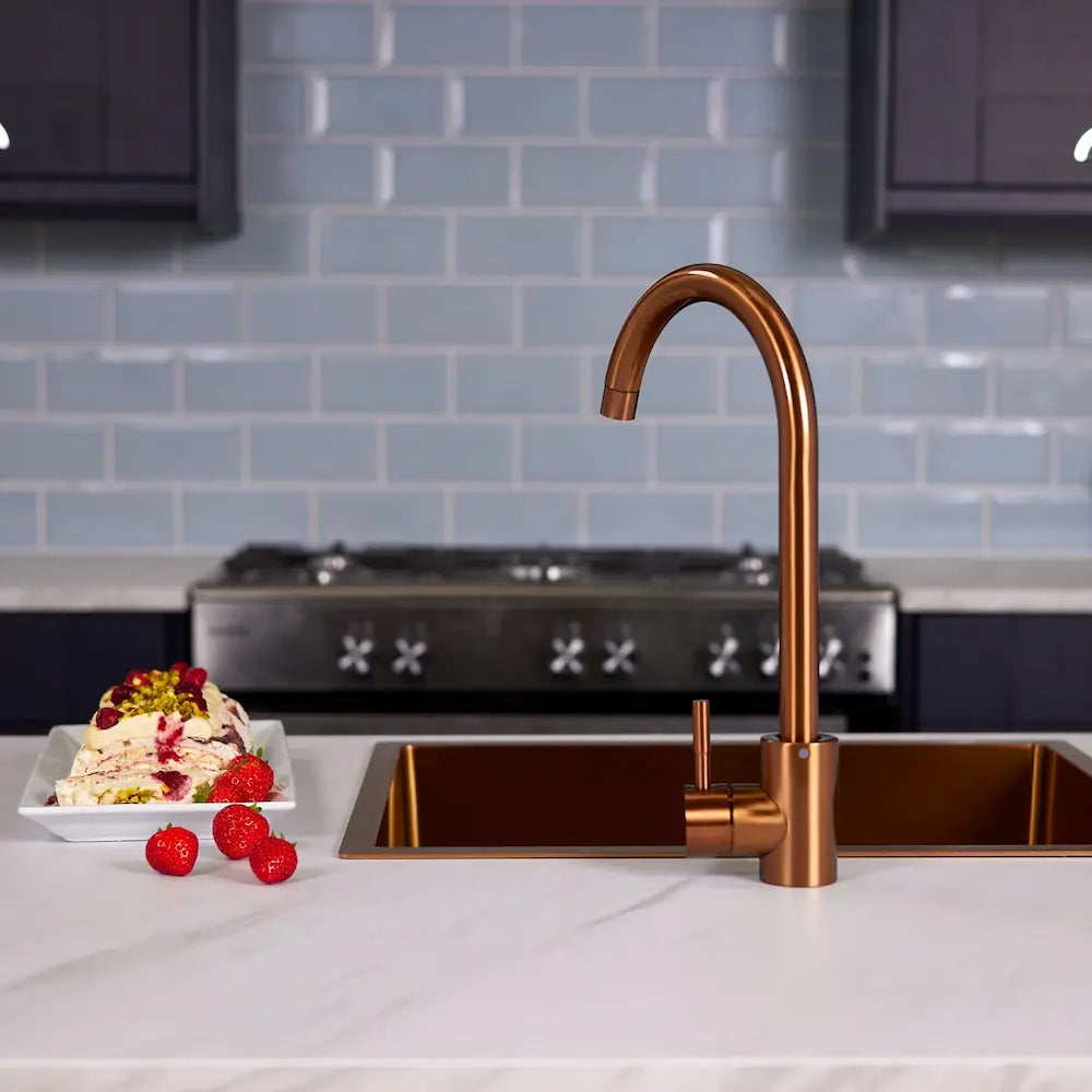 Tivoli copper kitchen sink tap in a navy kitchen with blue metro tiles and a range cooker