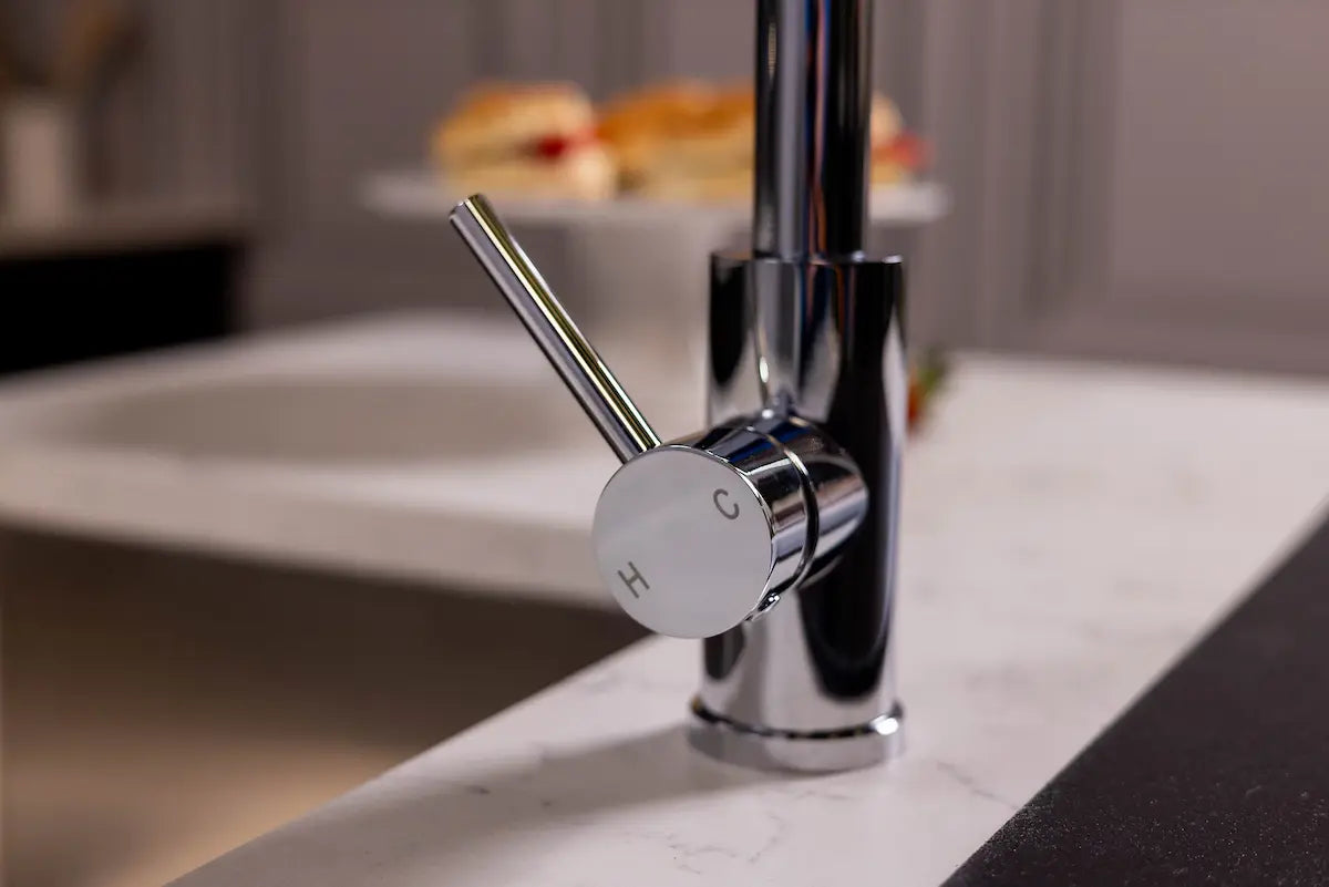 Chrome boiling water tap seen at an angle on a white worktop, showing the lever and squared spout profile