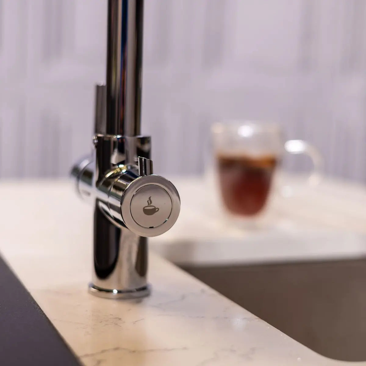 Close view of the boiling water lever and its safety button on the chrome tap body
