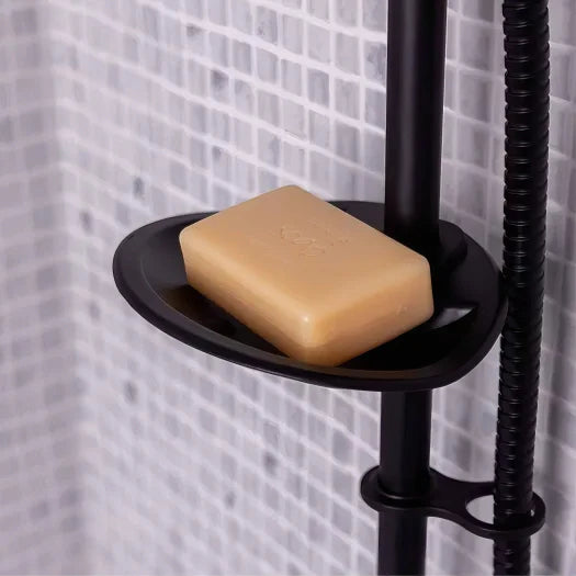 Black soap dish with a bar of soap against a tiled shower wall