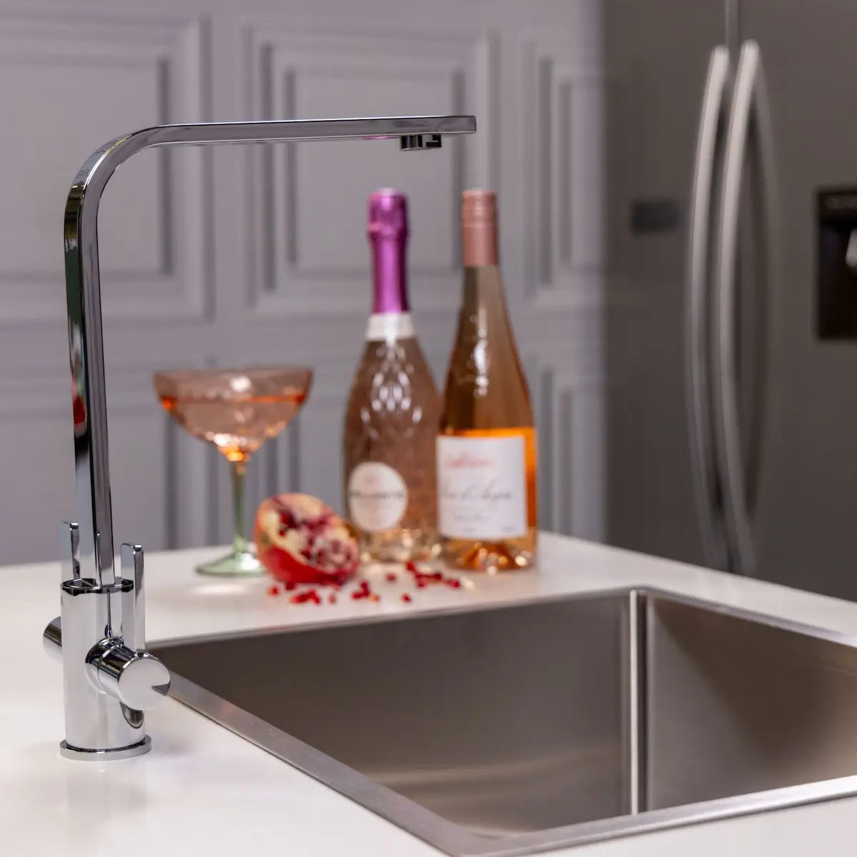 Side view of the Stroud chrome kitchen mixer tap fitted beside a stainless steel sink